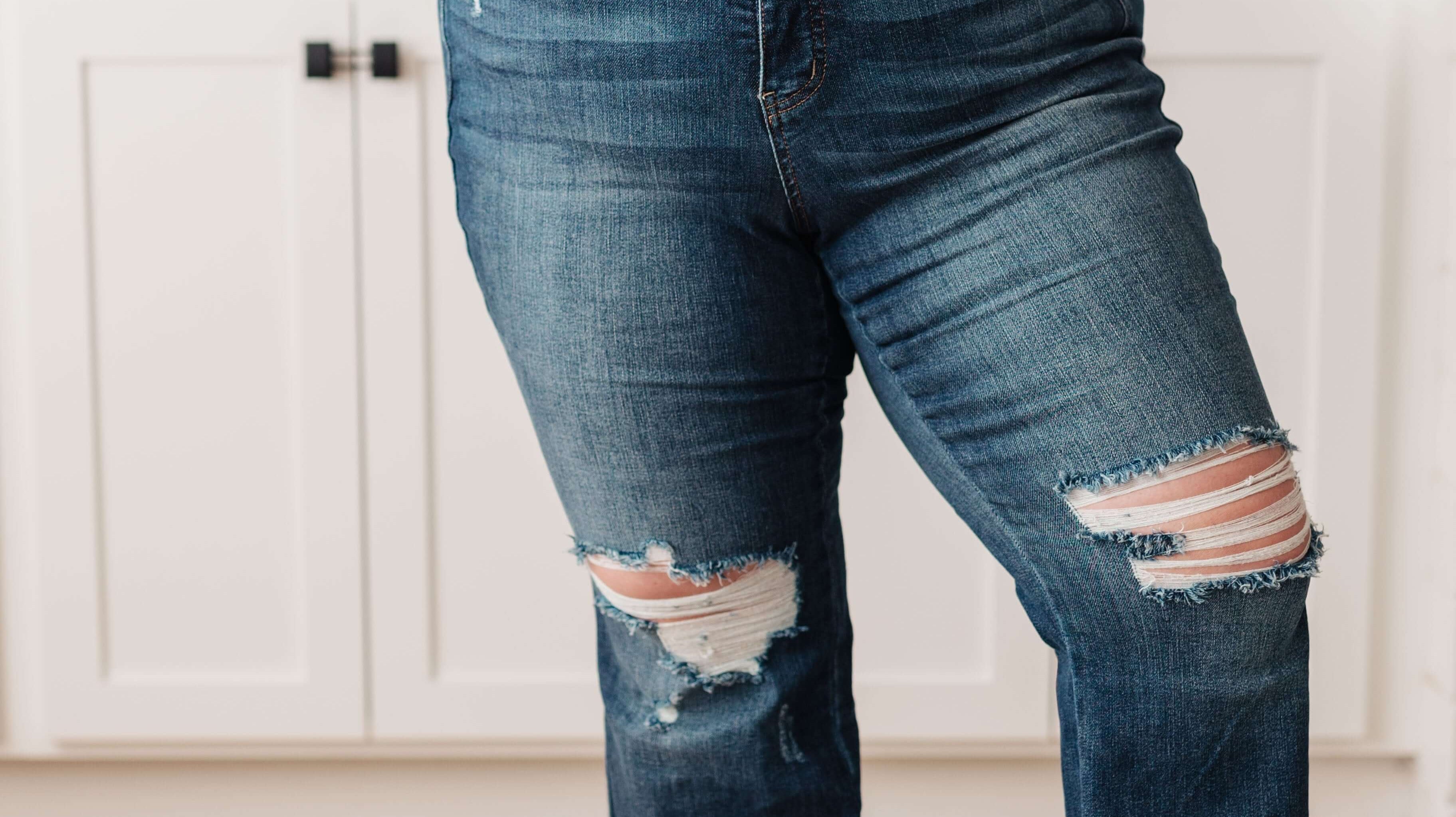 Woman wearing Judy Blue jeans with distressed details, showcasing a perfect fit and comfortable style.