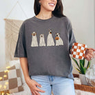 Woman wearing Spooky Dog Graphic Tee with cute dog illustrations, holding a checkered mug in cozy home setting.