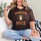 Woman wearing dark brown Take Me to the Pumpkin Patch Graphic Tee with Pumpkin Spice Latte design, sitting on a couch in ripped jeans