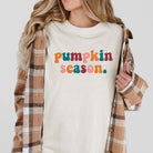 Woman wearing Pumpkin Season graphic tee with multicolor DTF printing and plaid jacket