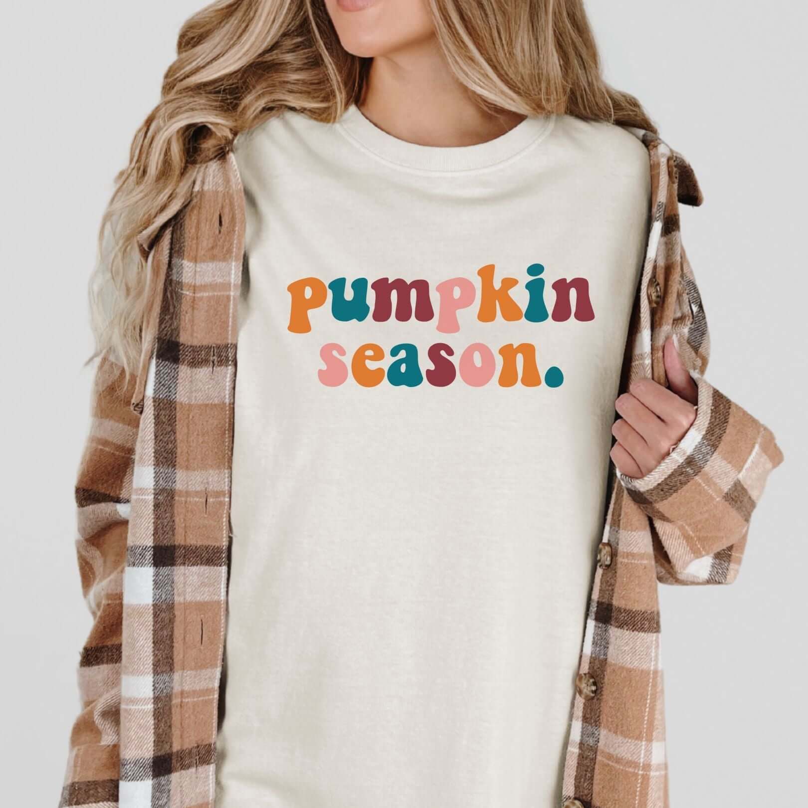 Woman wearing Pumpkin Season graphic tee with multicolor DTF printing and plaid jacket