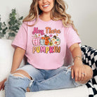 Woman wearing Hey There Pumpkin graphic tee in pink with multicolor DTF printing, showcasing casual style and relaxed unisex fit.