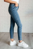 Woman wearing Nicole Tummy Control Skinny Jeans in vintage wash denim, showcasing high waist and skinny leg silhouette with white sneakers.